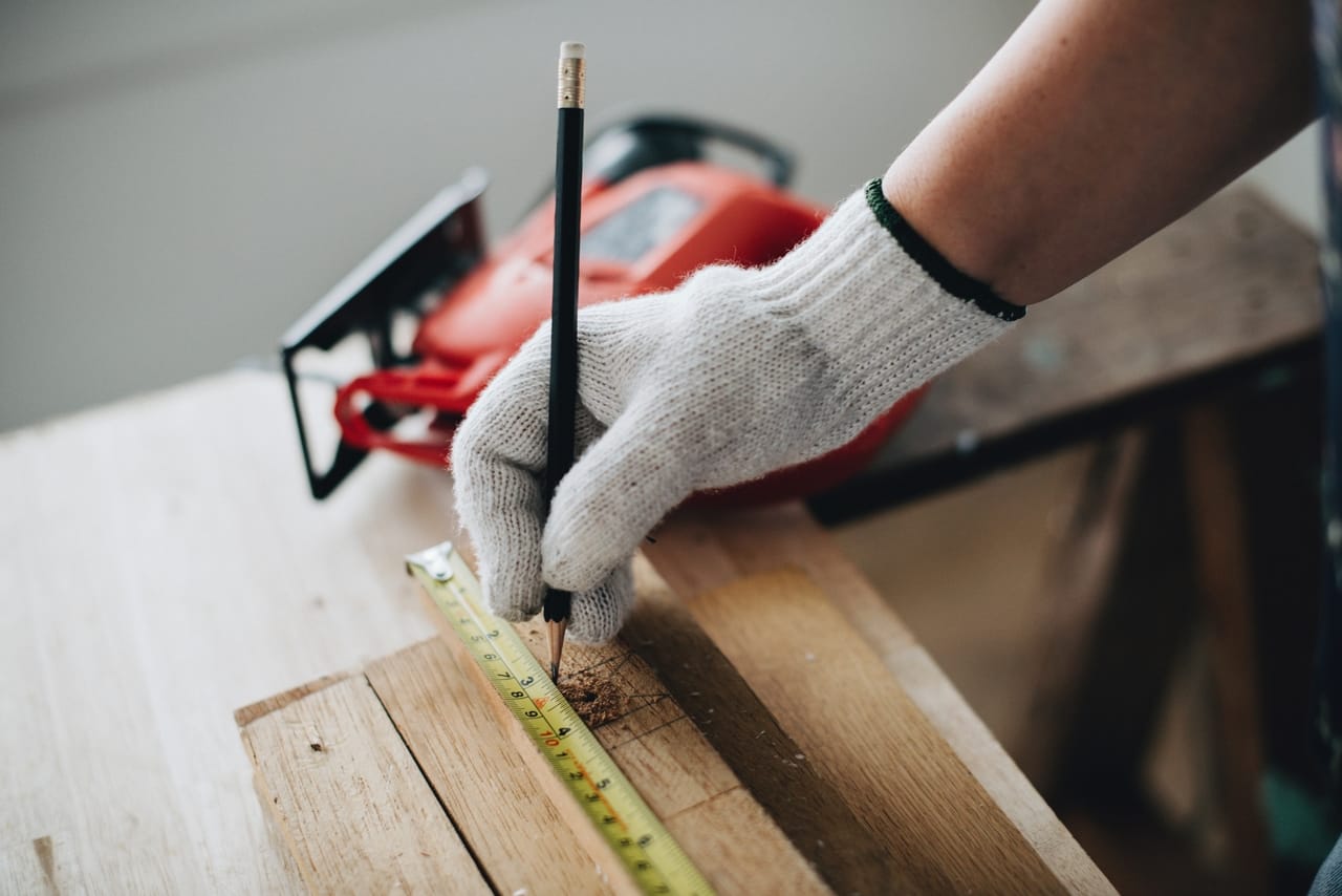 person-measuring-length-of-construction-wood